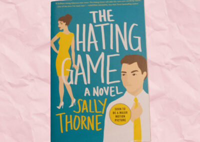 A blue book cover with a man in a yellow tie in the right bottom corner and a woman in a yellow dress in the middle left