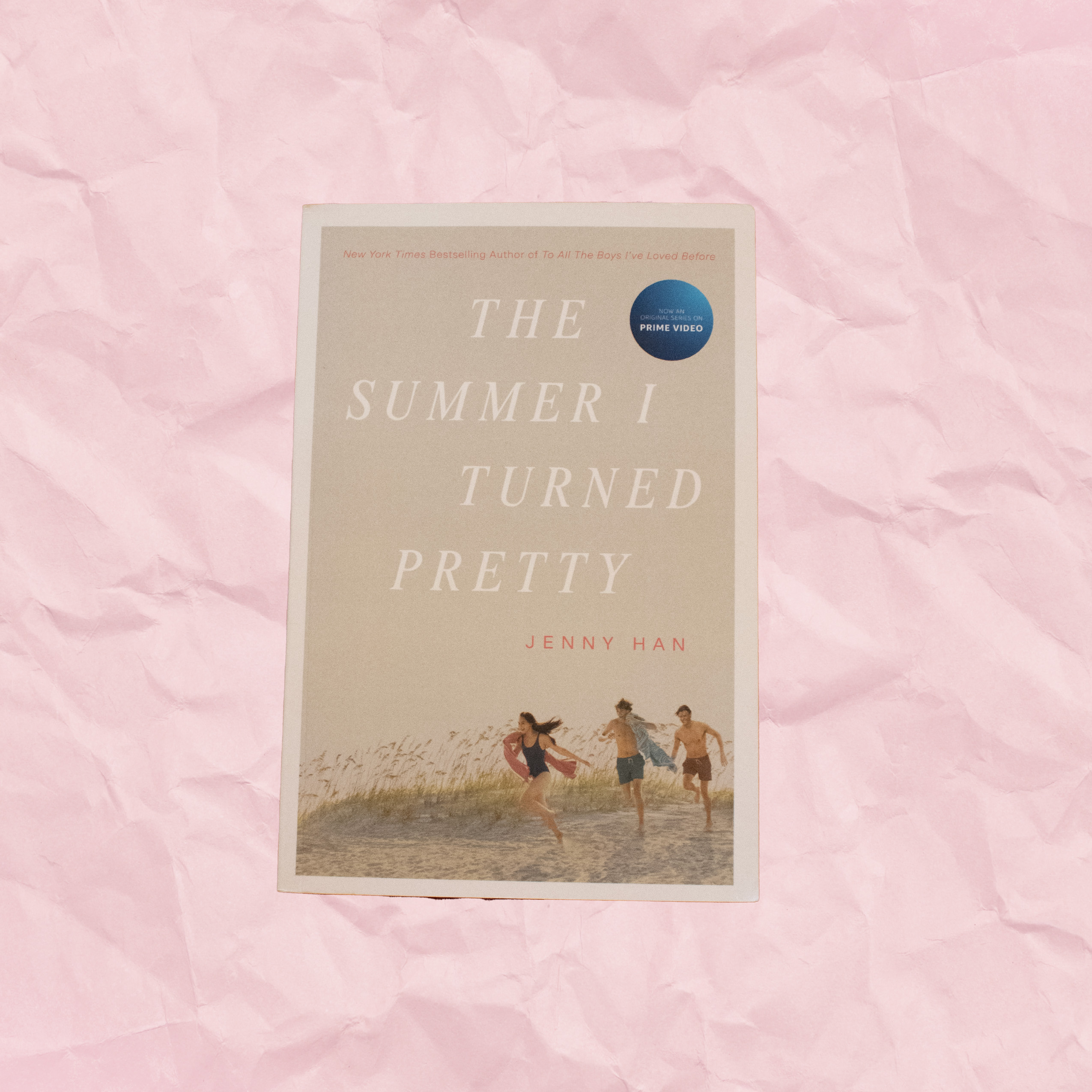 thesummeriturnedpretty Tan book cover with a girl and two boys running on a beach